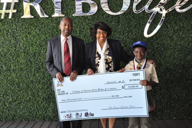Derron Blake Jr., right, poses with Dr. Ben and Candy Carson and his $1,000 scholarship check.