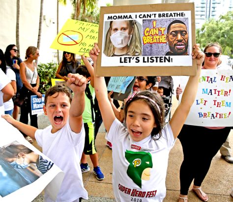 Ryan Pazze, 8, and Melanie Montes, 7, at an “Un-mask Our Kids” rally at the School Board administration building on May 19, 2021. Twenty-one speakers signed up to speak about masks during public comment. Many are against masks in schools. CHARLES TRAINOR JR CTRAINOR@MIAMIHERALD.COM