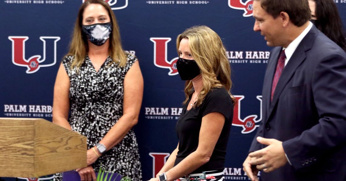 Sarah Painter, a fifth-grade teacher at Eisenhower Elementary and 2020-21 Teacher of the Year for Pinellas County Schools, center, is introduced by Gov. Ron DeSantis